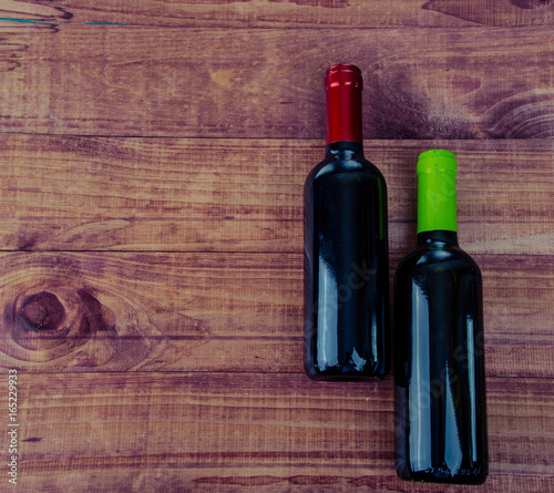 Top view of two wine bottles on a rustic wood table with copy space.