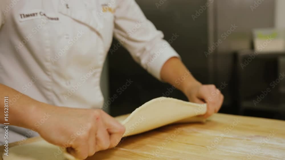Close up shot of man hands rolling dough to the circle for the bread on the wooden table in the bakery. Close up shot of man hands rolling dough to the circle for the bread on the wooden table in the bakery.