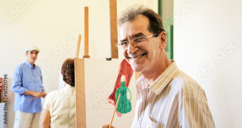 Old Man Painting Happy Senior People At Art School photo