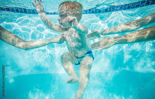 Little boy learning to swim underwater