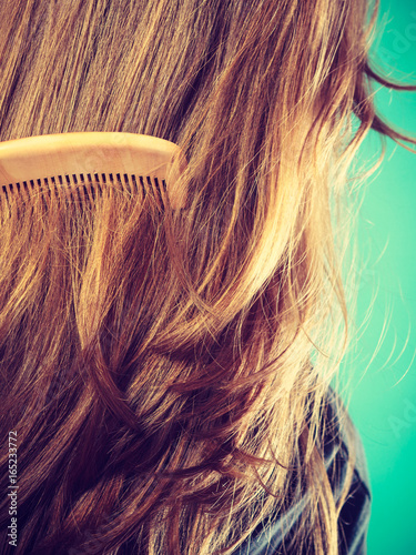 Straight brown hair with wooden comb closeup