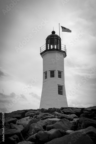 A black and white photograph of an isolated lighthouse