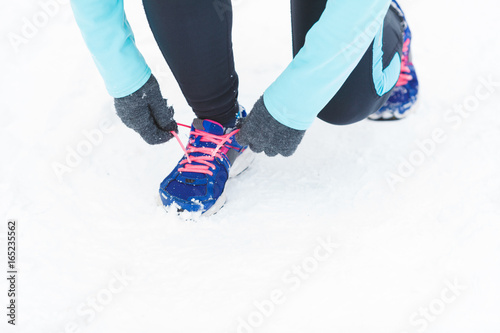 Tying sport shoes in snow