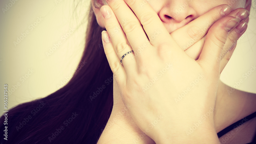 Fototapeta premium Woman covering her mouth with hand