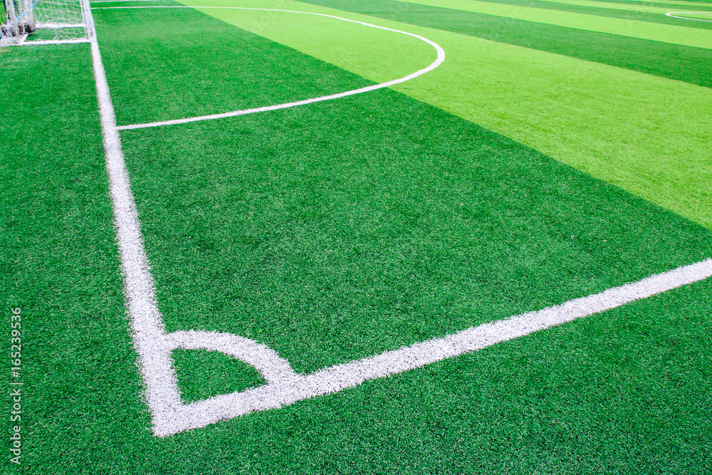 Photo of a green synthetic grass sports field with white line shot from above