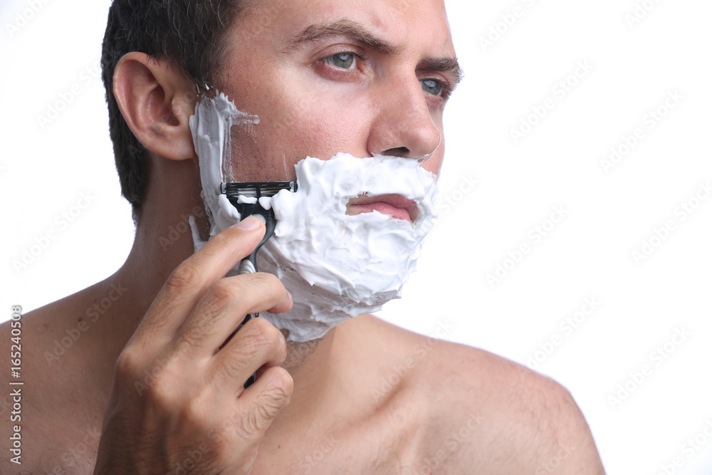Young man shaving beard