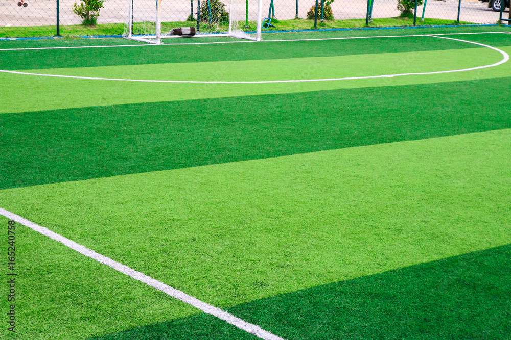 Obraz premium Photo of a green synthetic grass sports field with white line shot from above
