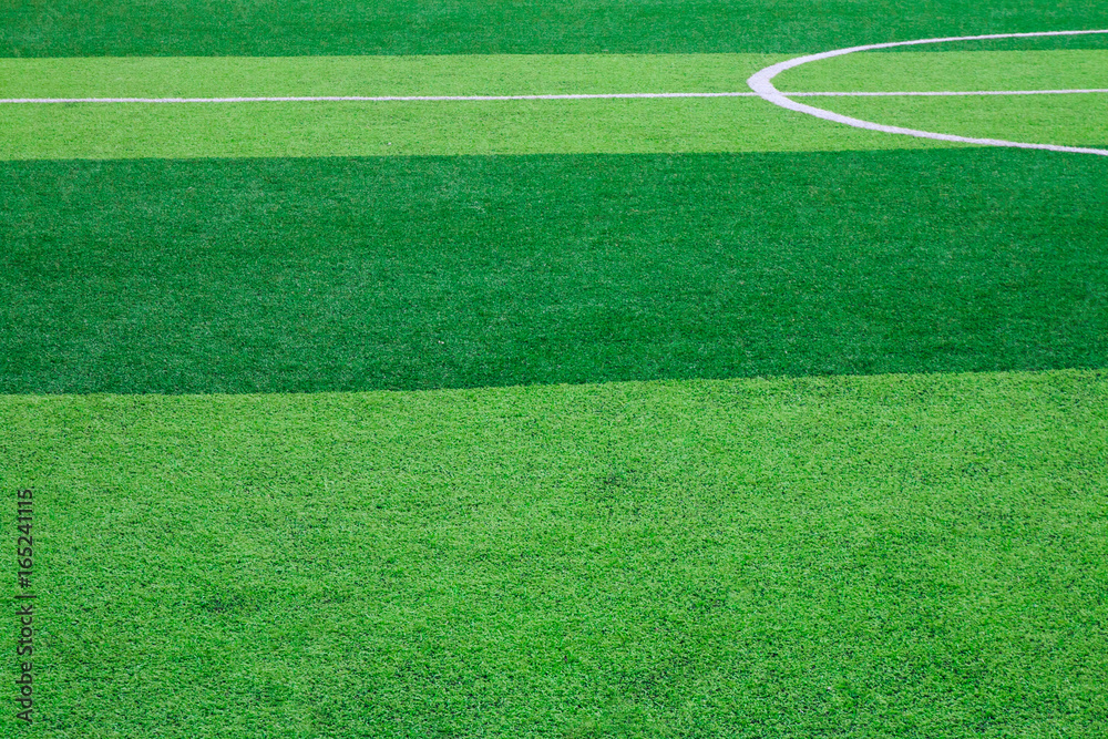 Obraz premium Photo of a green synthetic grass sports field with white line shot from above