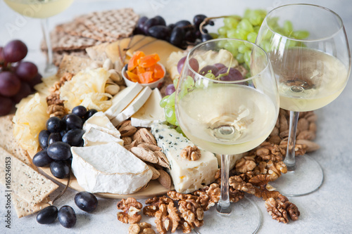 Cheese plate served with grapes, jam, cured melon, crackers and nuts