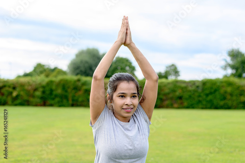 Teenage girl practising yoga outdoors © michaelheim