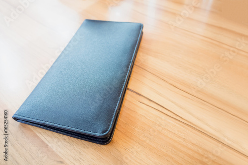 black leather restaurant payment billing receipt folder on wood table photo