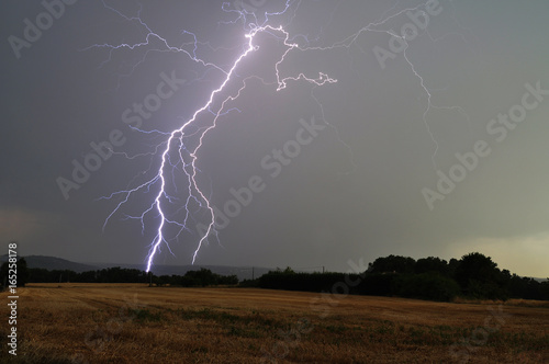 Lightning strikes in the valley (Dordogne, France) at the golden hour