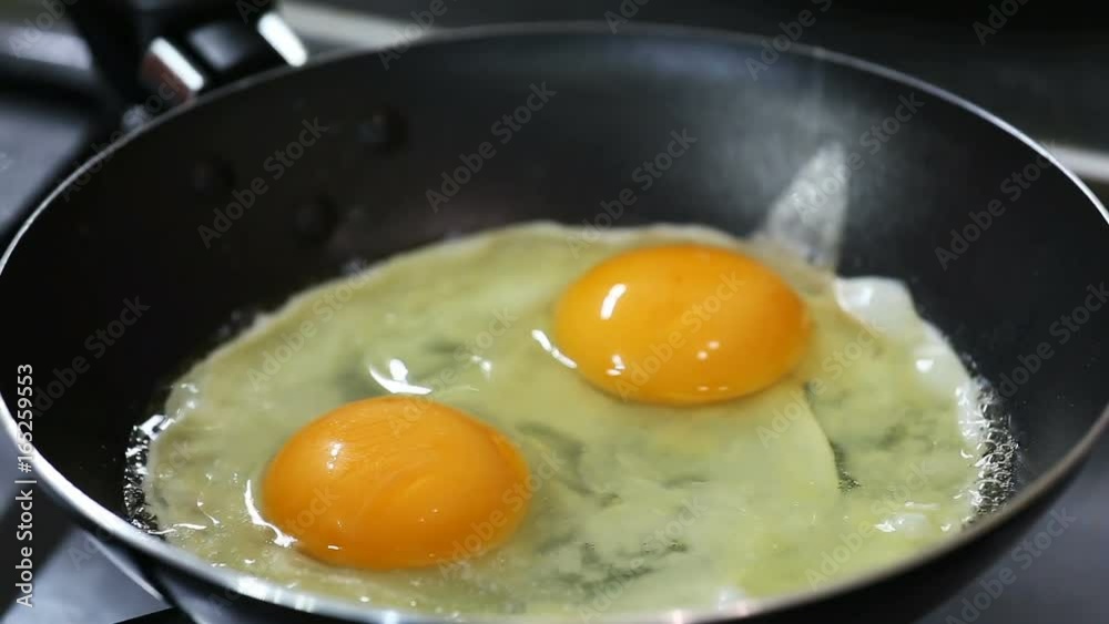Closeup two eggs are frying on a hot frying pan. Shallow focus. Closeup two eggs are frying on a hot frying pan. Shallow focus.