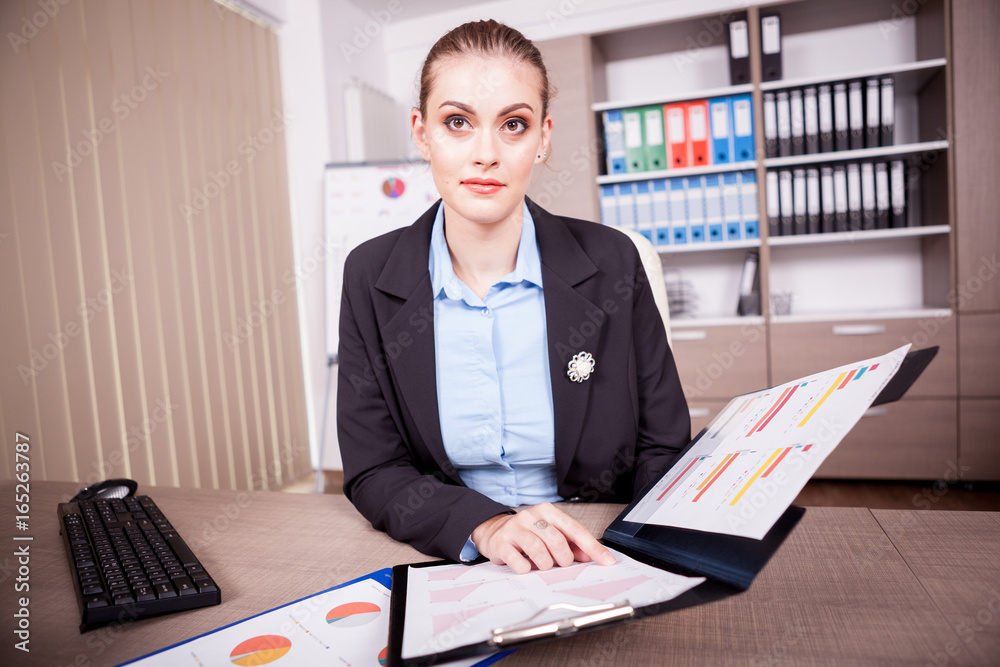 Woman in office with a chart folder in hands. Finance and business Woman in office with a chart folder in hands. Finance and business