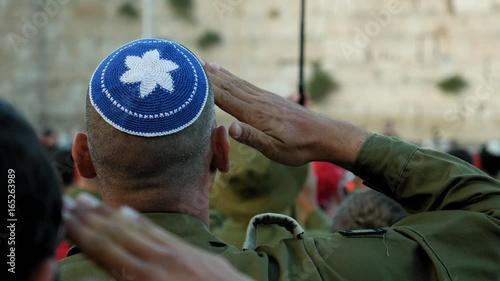 Israeli soldier military man saluting to the Western wall in Jerusalem. Western wall or Wailing wall or Kotel is the most sacred place for all jewish people.
