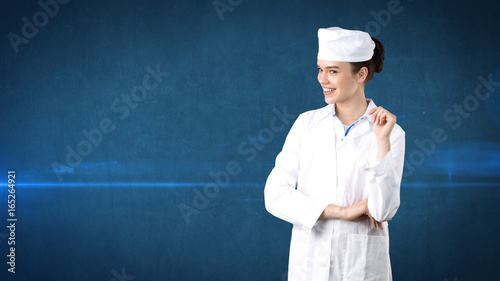 Beautiful medical woman doctor in uniform. Studio painted background. Concept of profitable health care.