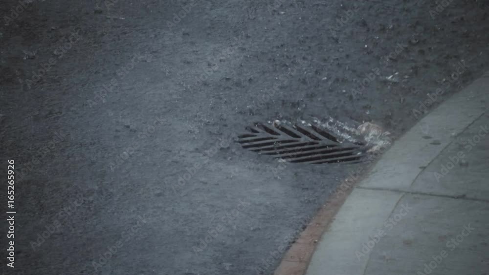 Cinematic closeup of a hard rain falling on the street.