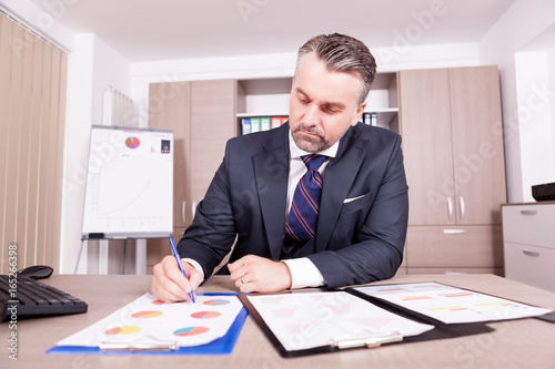Businessman working on the charts in his office. Business and corporate. Confident CEO