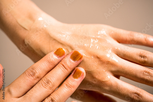 手のひらにクリームを塗る女性