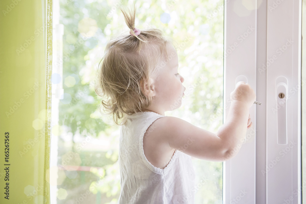 Child opens window with lock close up. Child at window macro. Window with lock for children's Child opens window with lock close up. Child at window macro. Window with lock for children's