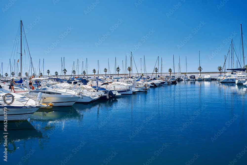 Yacht harbor in blue sunset light, luxury summer cruise, leisure time, active life, vacation and holidays concept Yachts and their reflection in the city's port.