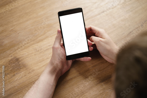 young man hands holding smartphone with blank white screen