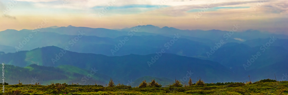 Panorama of mountain ridges with clouds and fog in the morning evening time, at sunrise, sunset