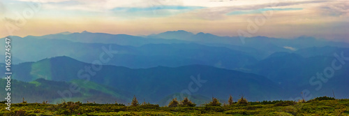 Panorama of mountain ridges with clouds and fog in the morning evening time, at sunrise, sunset