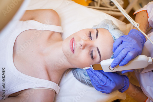 Cosmetology doctor makes facial procedures photo