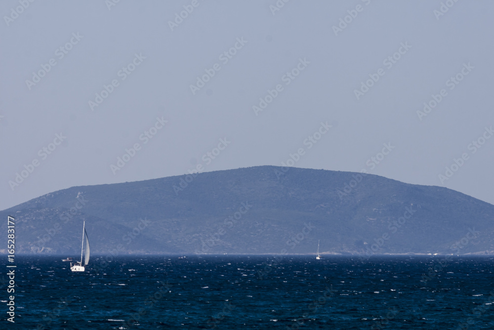 White sailboat on the blue aegean turkish sea