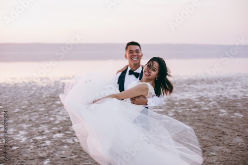 Wedding couple walking along the shore of the estuary