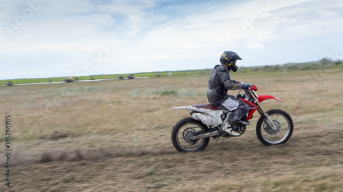 Fototapeta Naklejka Na Ścianę i Meble -  Motorcycle hard cross goes to competitions on a dirty road