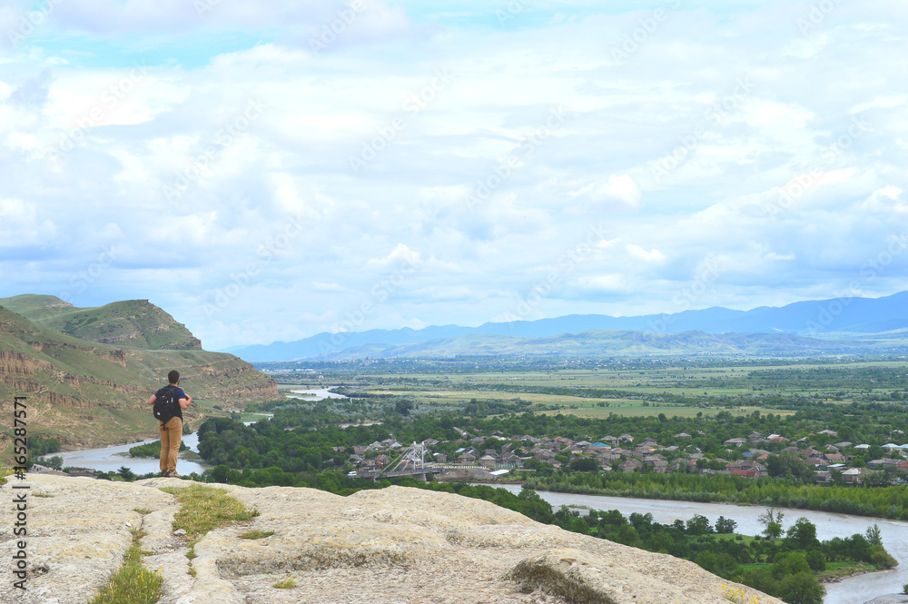 Backpacker in Uplistsikhe caves and rocks panorama