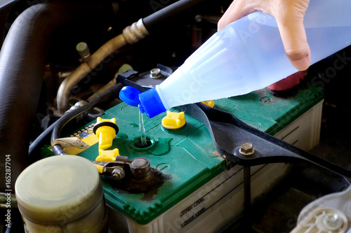 the man are add distilled water to the battery pack