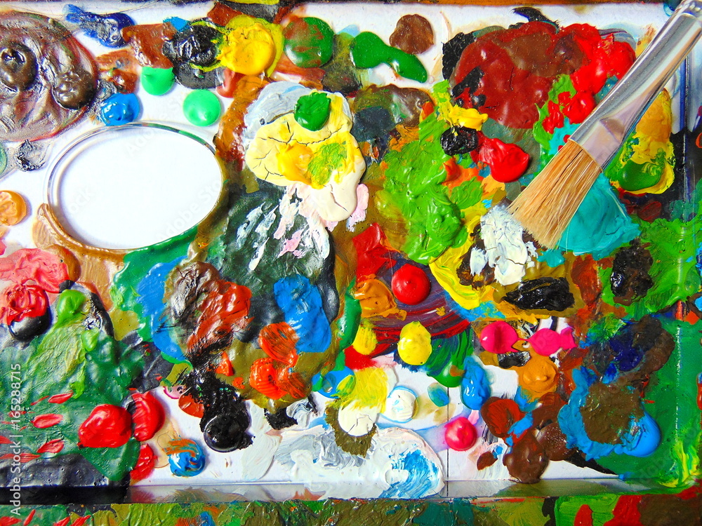 colorful dried paint on mixing palette with painting brush
