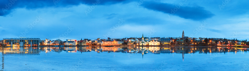 Beautiful panorama of the skyline cityscape of Reykjavik, reflected in lake Tjornin at the blue hour in winter - obrazy, fototapety, plakaty 