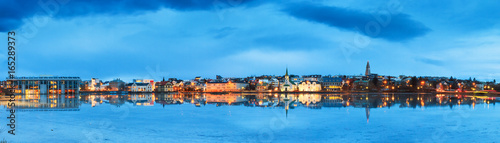 Beautiful panorama of the skyline cityscape of Reykjavik, reflected in lake Tjornin at the blue hour in winter