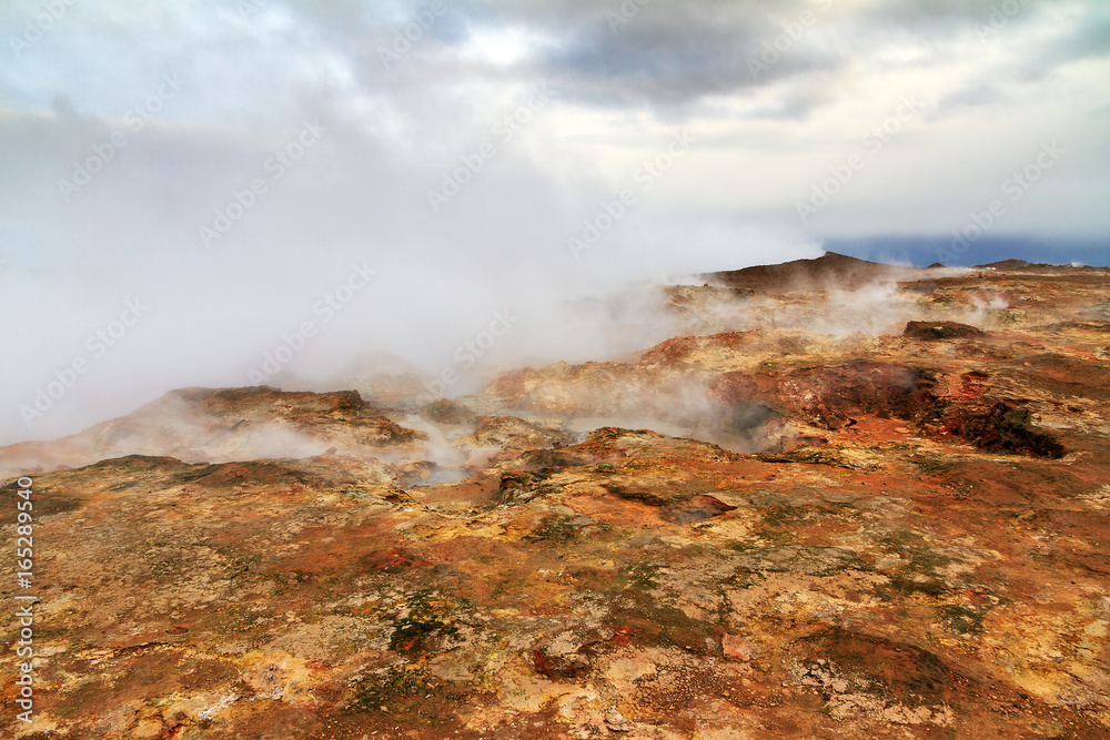 Colorful geothermal area Gunnuhver, with steam vents and a geothermal powerplant, in Iceland