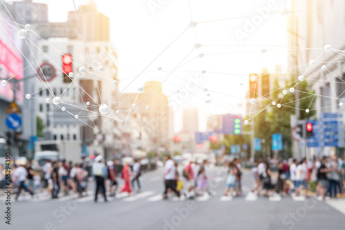 Fototapeta Naklejka Na Ścianę i Meble -  Internet of things , iot , smart city , big data technology concept. Neural networks connect atoms and blur city people cross street background. Flare light effect , 3d Rendering.