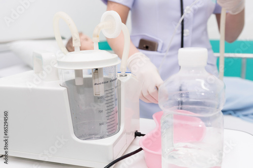 Photography Nurse use Suction Machine, prepare to suction patient's mucus.