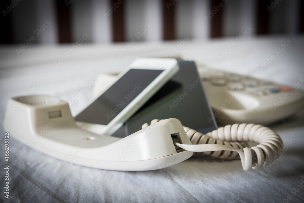 Old telephone and new mobile phone , selective focus Old telephone and new mobile phone , selective focus
