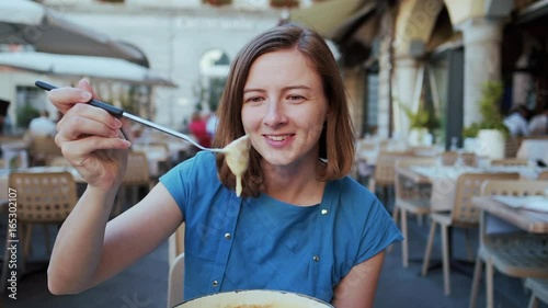Woman eating Swiss cheese fondue having dinner in Switzerland. Woman eating local food having fun on travel in Europe. Romantic couple outdoors in summer.