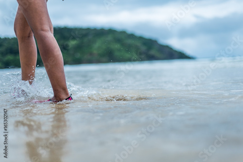 Woman standing in the water with aqua shoes