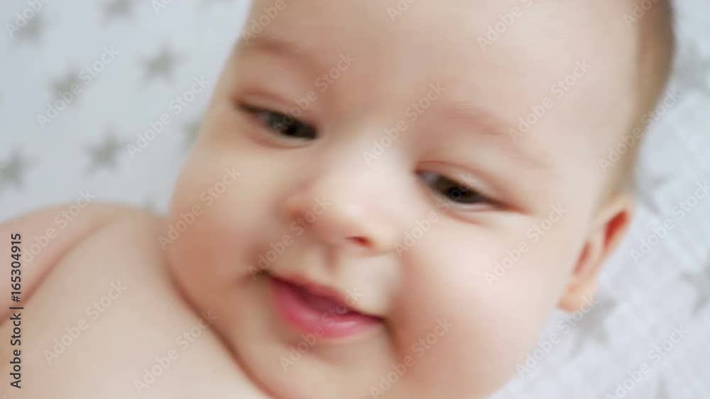 portrait of a child of four months lying on her back on the diaper with stars portrait of a child of four months lying on her back on the diaper with stars