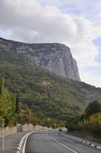 The machine moves on the road against the backdrop of the mountains