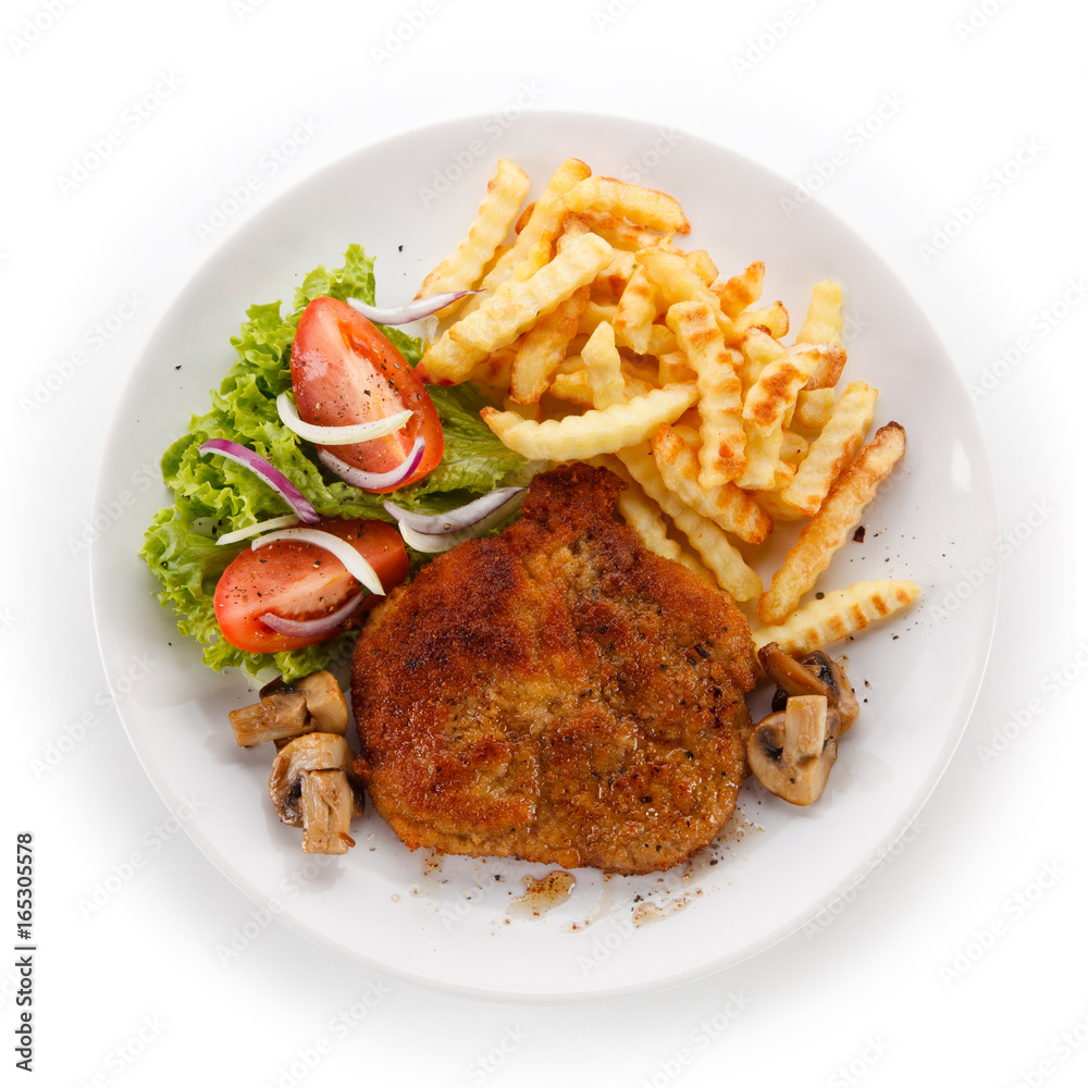 Fried pork chop, French fries and vegetable salad on white background Fried pork chop, French fries and vegetable salad on white background