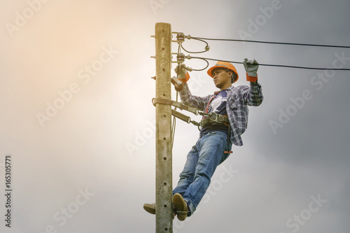 Electrician climbing poles, repairing power lines.