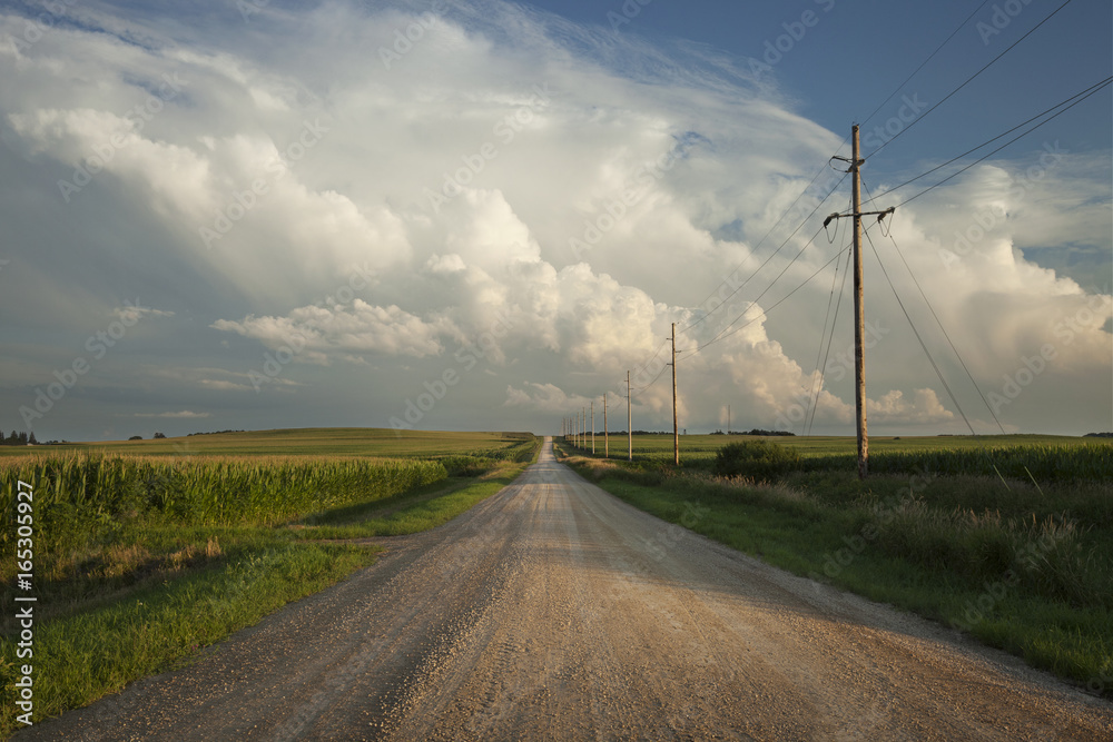 Rural road with dramatic clouds in southern Minnesota at sundown