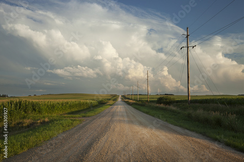 Rural road with dramatic clouds in southern Minnesota at sundown
