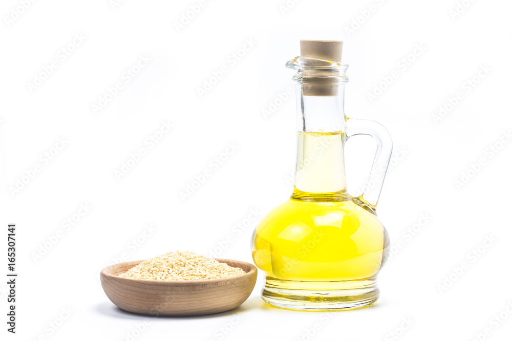 Sesame seeds and bottle with oil on a old wooden table?Sesame oil oil in a glass jug. Sesame seeds and bottle with oil on a old wooden table?Sesame oil oil in a glass jug.